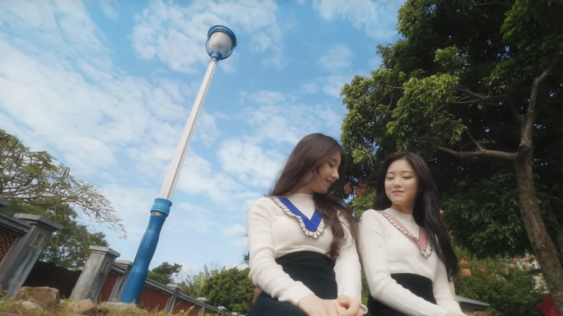 Heejin and Hyunjin sitting in a park.